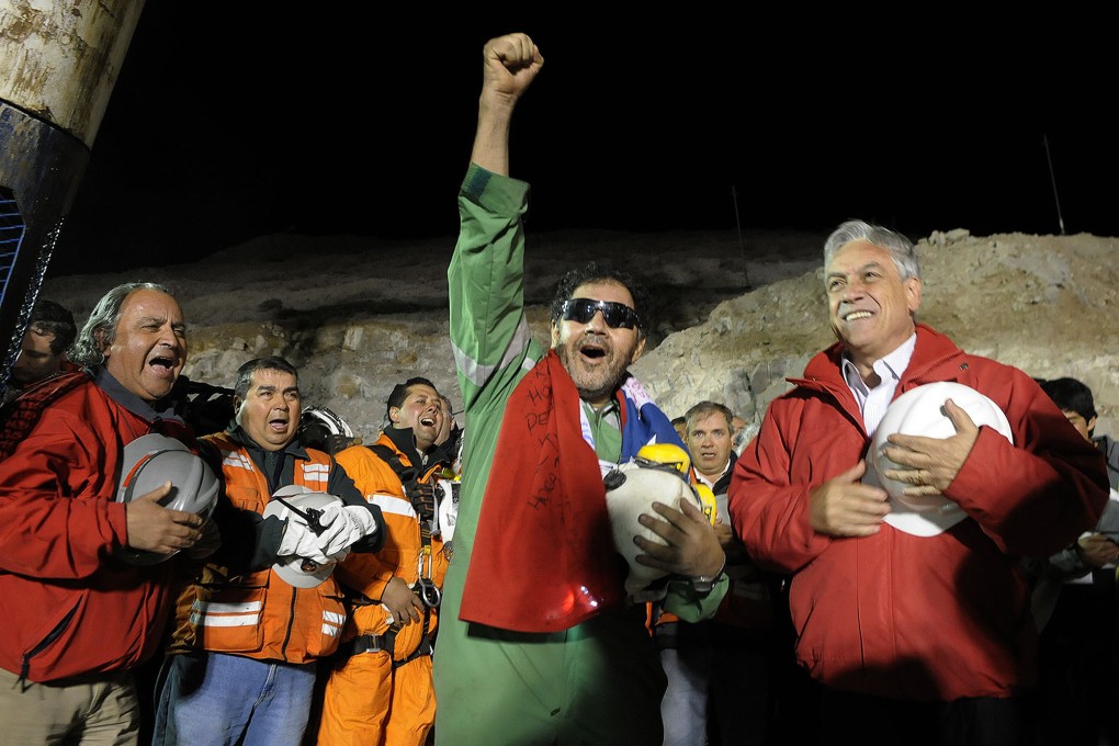 Chile's President Sebastian Pinera, right, stands next to the the last miner to be rescued, Luis Urzua, centre. Photo: AP