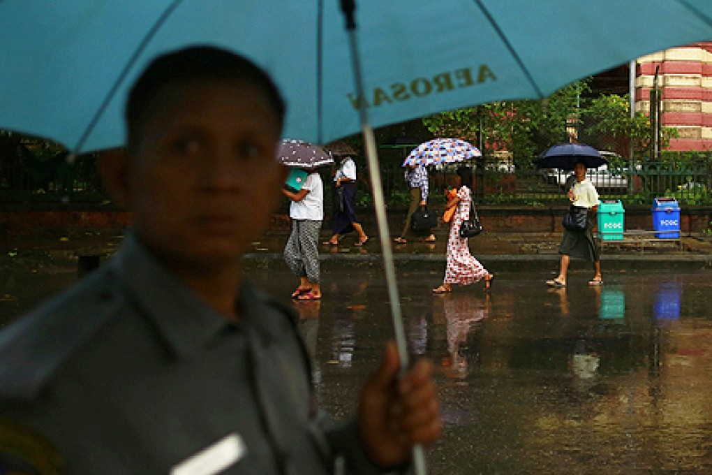 People use umbrellas as rain falls in Yangon. Photo: Reuters