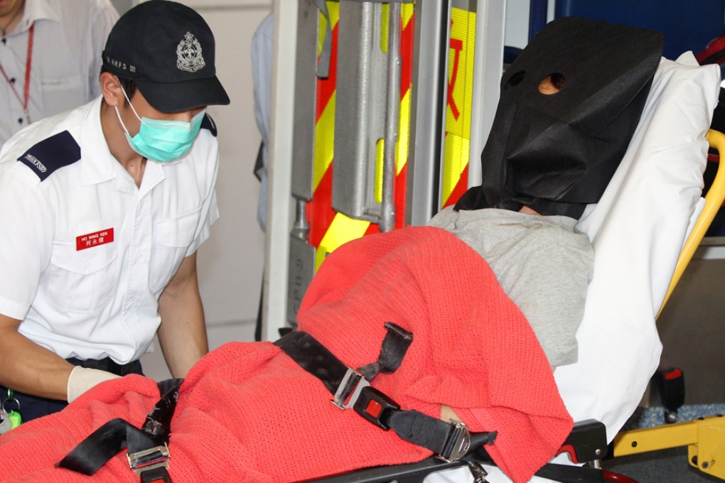 The suspect who uses a cleaver to attack passengers on board a coach in Tuen Mun is transferred from Tuen Mun Hospital to Castle Peak Hospital. Photo: Sam Tsang