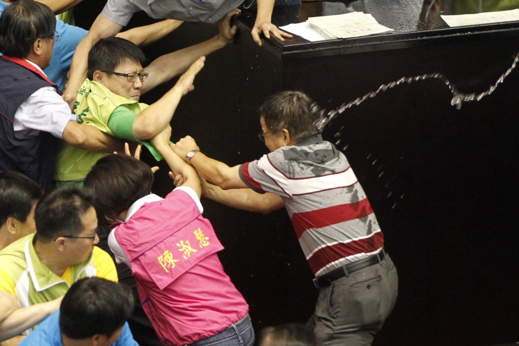 Ruling and opposition lawmakers are sprayed with water as they fight on the legislature floor in Taipei in Taiwan on Friday. Photo: AP