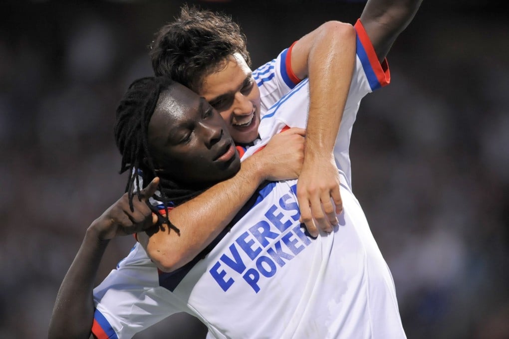 Lyon's French forward Bafetimbi Gomis (down) is congratulated by Lyon's Croatian defender Lovren Dejean. Photo: AFP