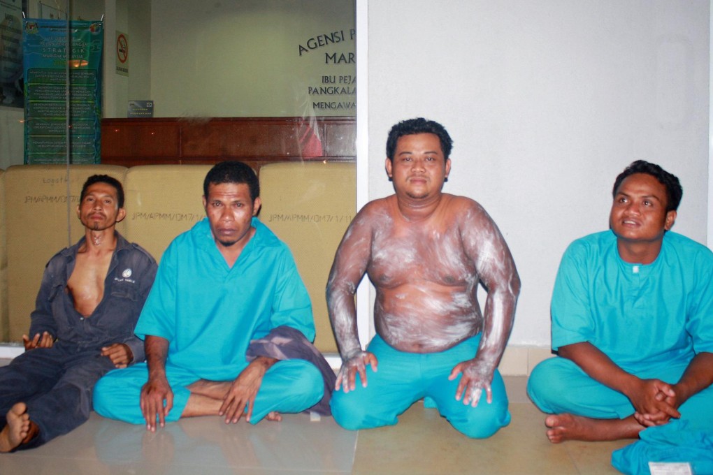 The survivors at a government office in Tanjung Sedili. Passengers on the boat are believed to have been illegal immigrants. Photo: AFP