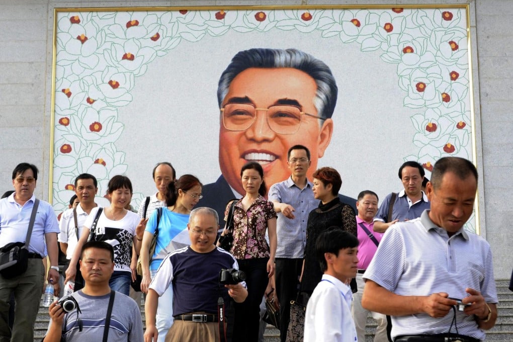 Chinese tourists leave after paying homage to a giant portrait of Kim Il-sung at a square in Rason, but the mausoleum for Kim and his son Kim Jong-il is not on their itinerary. Photo: AFP