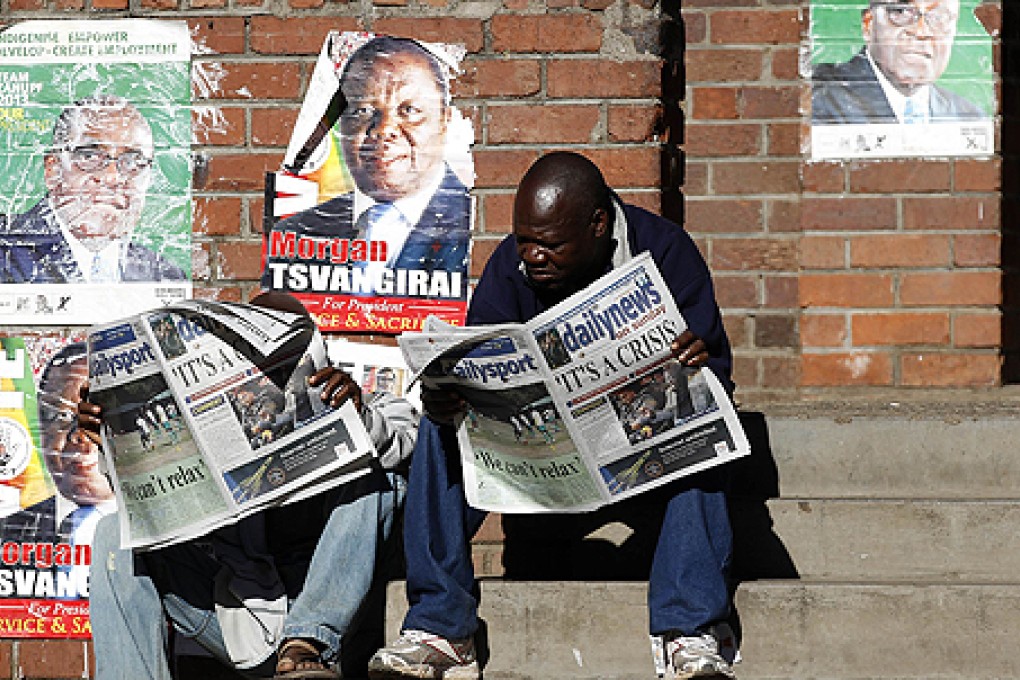 Locals read the news about the presidential election in Mbare township, outside Harare. Photo: Reuters