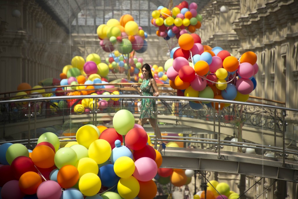 A shopper crosses a bridge at GUM, Moscow’s historic and arguably best known shopping mall. Photo: AFP