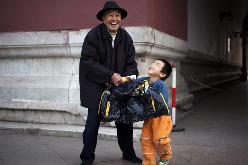 An elderly man plays with his grandson in Beijing in 2011. By 2015, the mainland would move to a two-child policy, a newspaper has reported. Photo: EPA