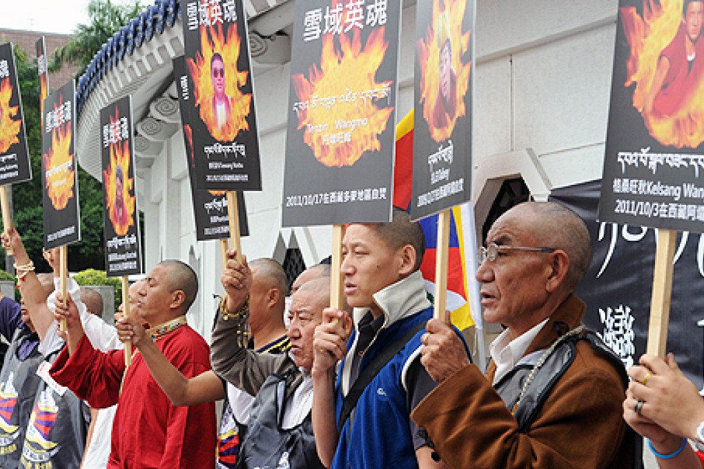 Tibetans display portraits of people who killed themselves in self-immolation, during a protest in Taipei in October. Photo: AFP