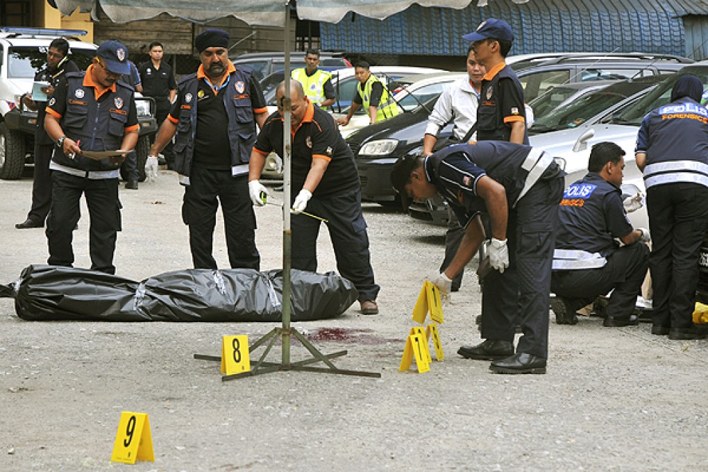 Malaysian forensic officers investigate the shooting of Hussain Ahmad Najadi in Kuala Lumpur. Photo: AP