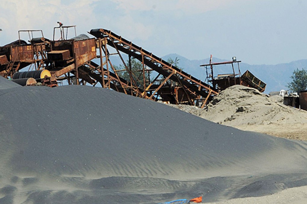 A stock pile of fine black sand can be seen at an abandoned magnetite or black sand mine, an iron ore that is in huge demand by China's steel mills. Photo: AFP