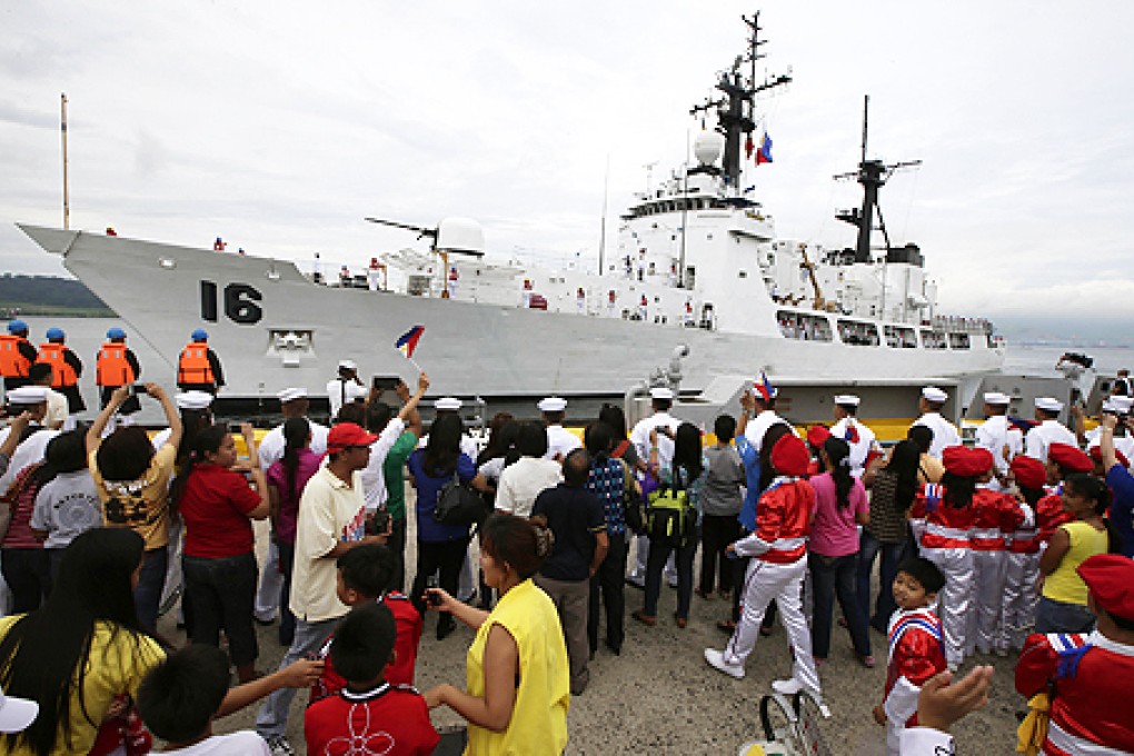 Students and other guests wave Philippine flags to welcome the second warship of the Philippine Navy, the BRP Ramon Alcaraz on Tuesday, at Subic Freeport. Photo: AP