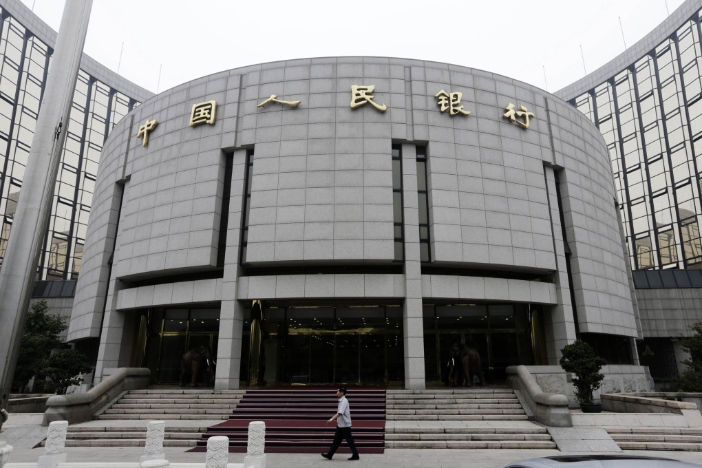 A staff member walks in front of the headquarters of the People's Bank of China (PBOC), the central bank, in Beijing. Photo: Reuters