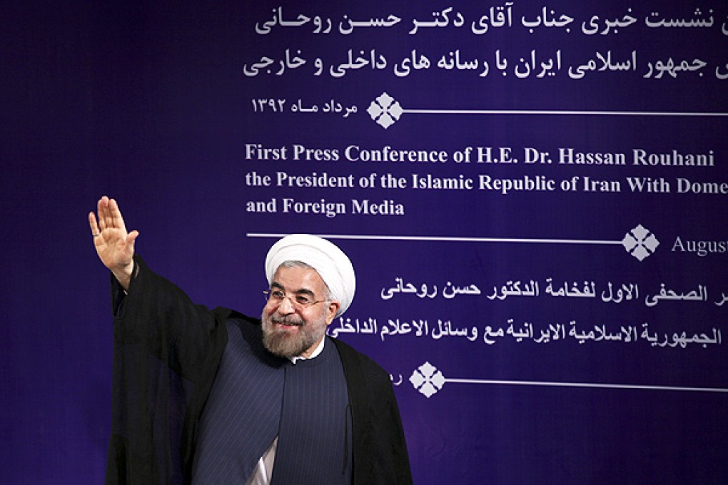 Iran's new President Hasan Rouhani waves to reporters at the conclusion of his first press conference since taking office at the presidency compound in Tehran. Photo: AP