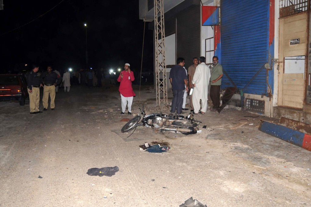 Rescuers work beside a damaged vehicle at the blast site in southern Pakistani port city of Karachi on Wednesday. Photo: Xinhua