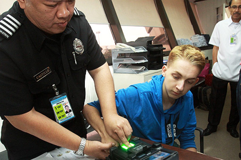Thomas van Beersum has his finger prints taken using a secure electronic enrollment kit at the immigration office of the international airport in Manila on Thursday. Photo: AFP