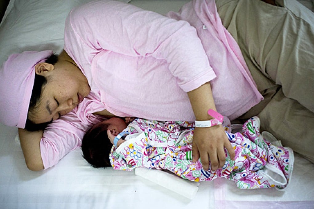 Chinese new mother Qi Wenjuan breastfeeds her one-day-old son at Tiantan Hospital’s maternity ward in Beijing, China. Photo: AP