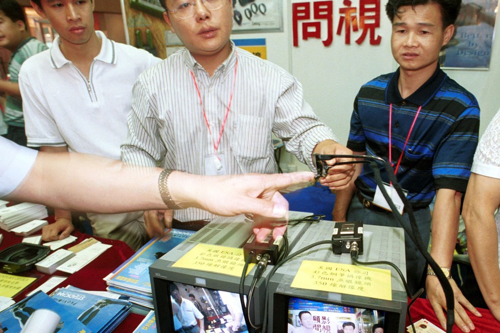 A vendor points out glasses that have a concealed video camera at a Beijing exhibition. Accusations of industrial espionage against China have surged in recent years. Photo: AP