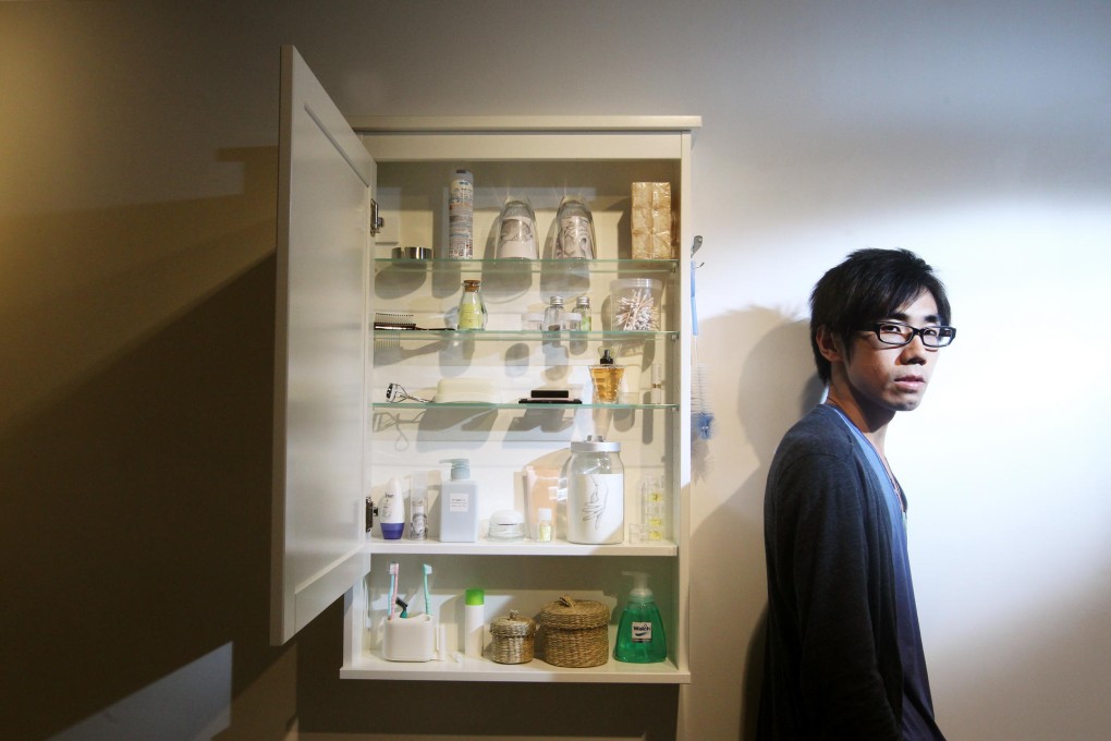 Artist Tang Kwok-hin with his work, at am space in Central. Photo: May Tse