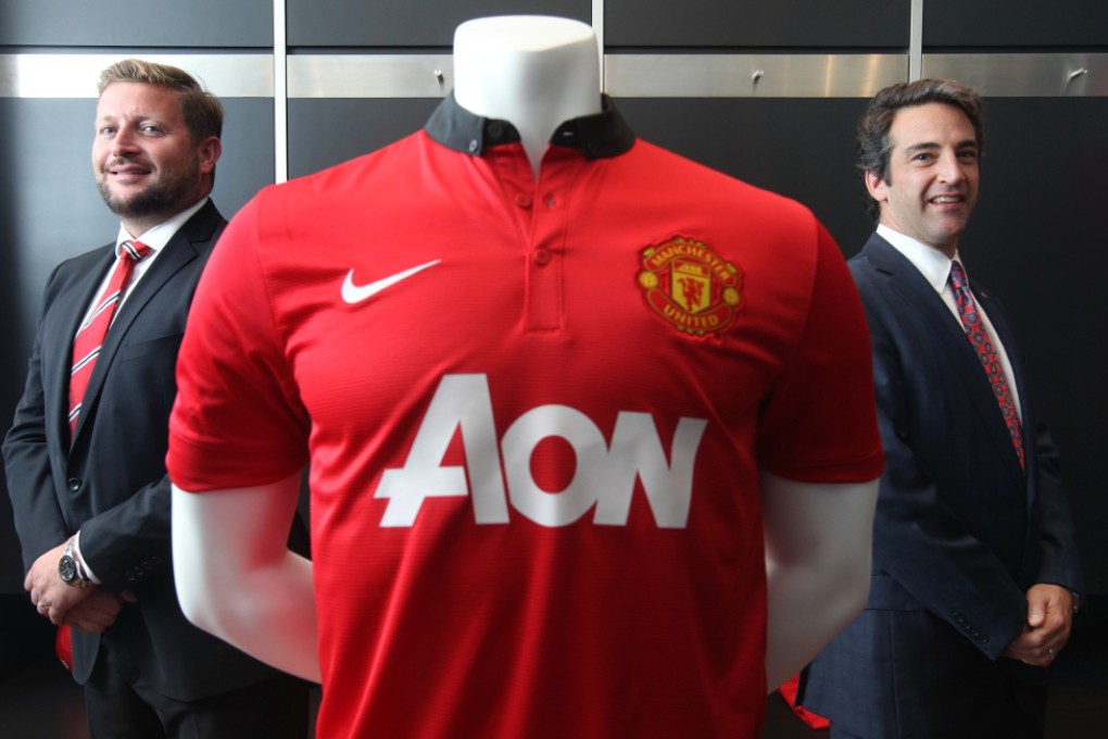 Richard Arnold (Left), Group Managing Director of Manchester United and Owen Belman (Right), Chief Executive Officer of Greater China Aon Risk Solutions, poses for photography at Manchester United Hong Kong office in Central