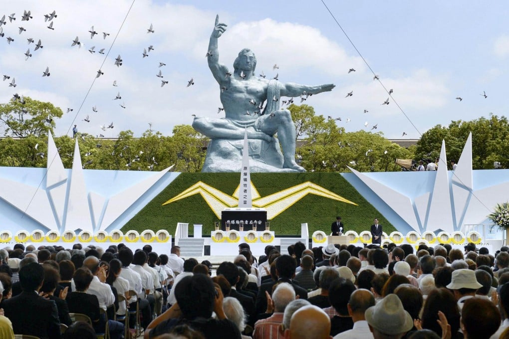 Doves fly near the Peace Statue in Nagasaki's Peace Park during a ceremony commemorating the 68th anniversary of the bombing