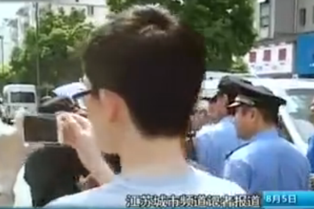 A man films local urban management officers. Photo: Screenshot from Sina
