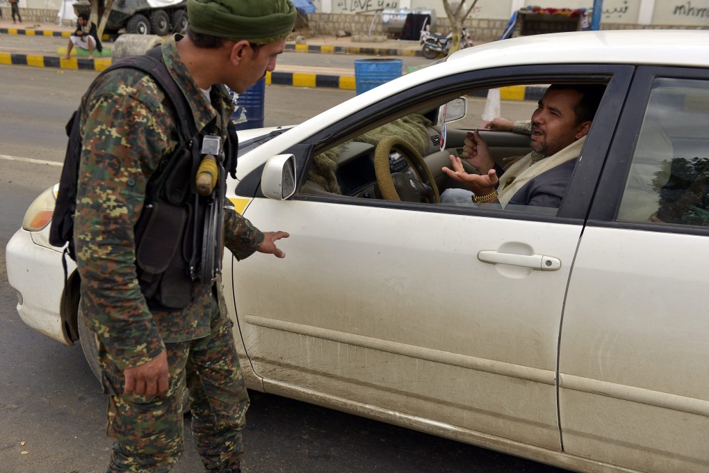 A Yemeni soldier inspects a vehicle at a checkpoint in Sanaa. Photo: EPA