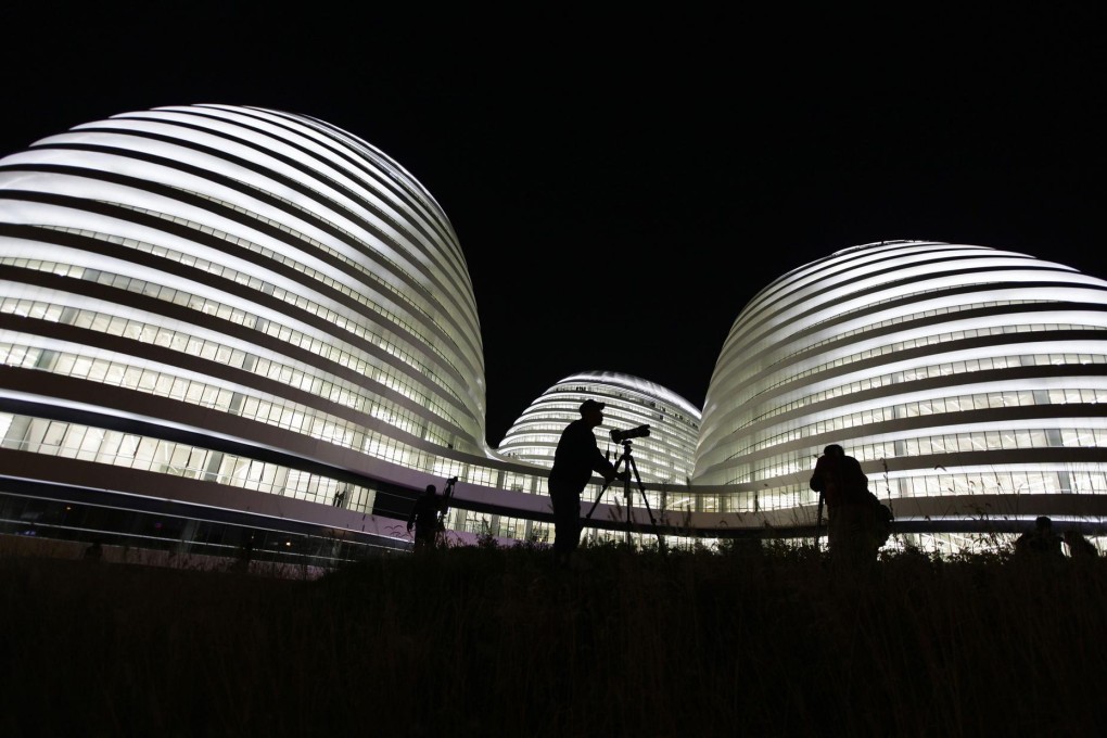A visitor photographs the new Galaxy Soho building. Critics say the building is out of context in old Beijing. Photo: Reuters