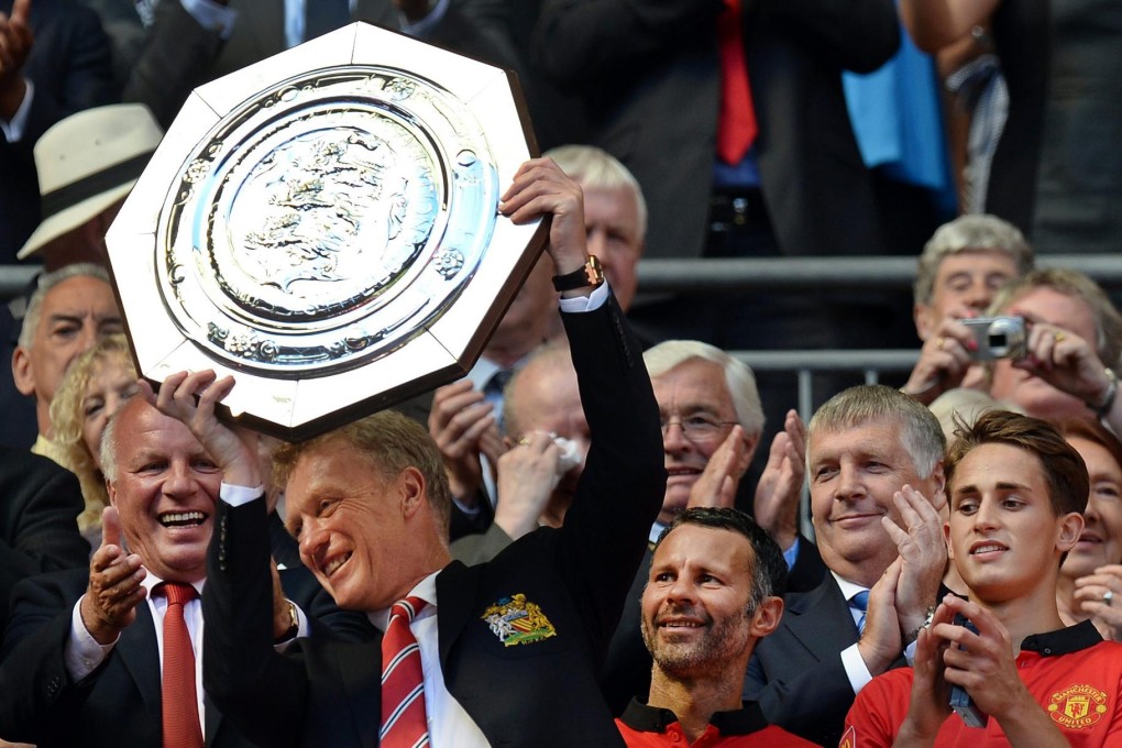 Manchester United manager David Moyes lifts the Community Shield after his side defeated Wigan 2-0 at a sun-baked Wembley yesterday. Photo: EPA