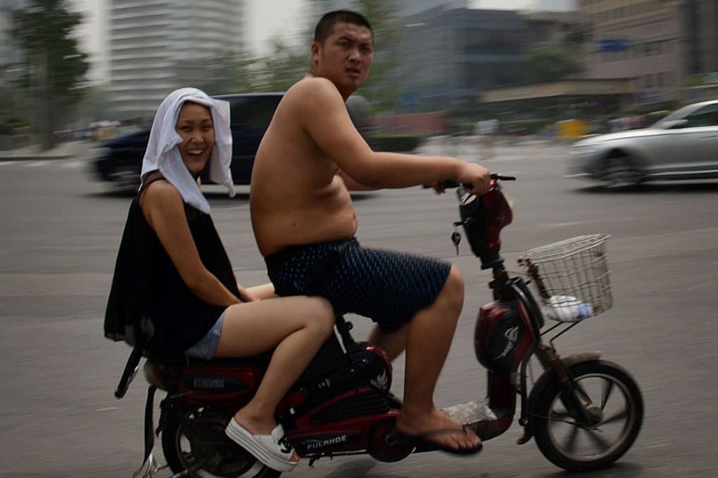 Commuters try to stay cool as high temperatures continue in Beijing. Photo: AFP