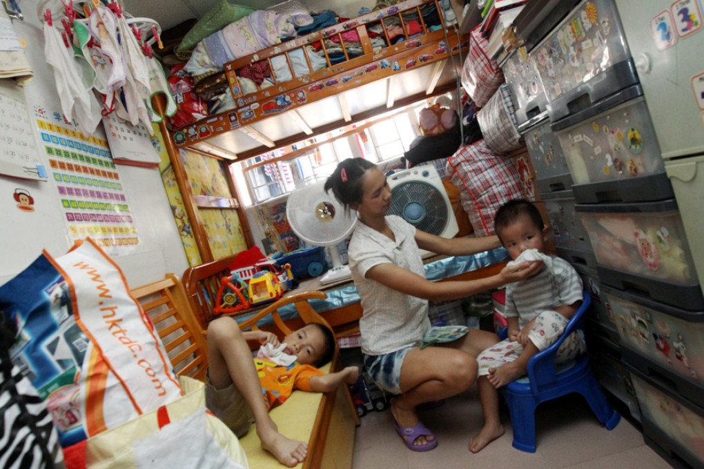 The temperature in this 100 sq ft subdivided flat in Kwun Tong, occupied by a family of five, including Mrs Zhang and her two sons, reached 35.7 degrees Celsius yesterday, five degrees higher than outside, according to the World Green Organisation. Photo: David Wong