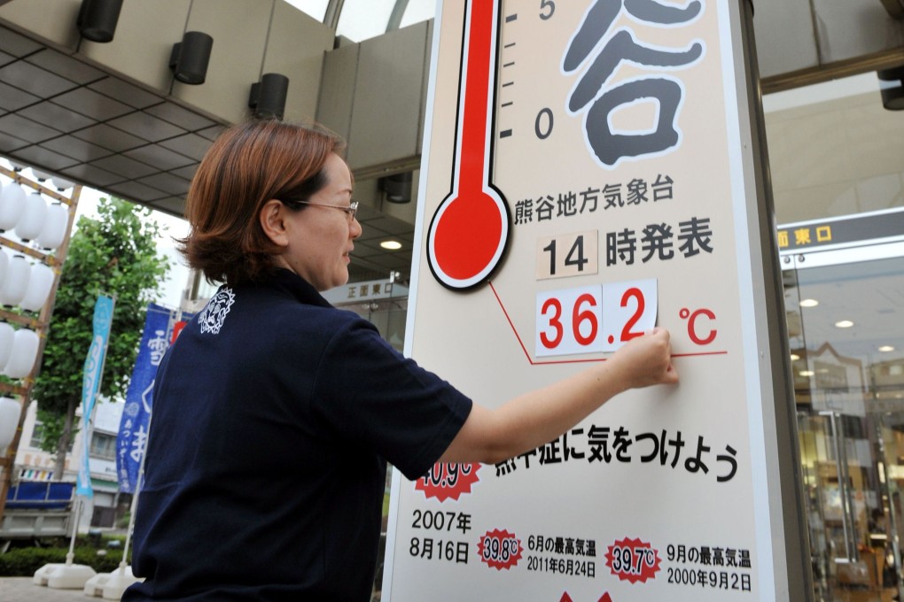 A worker at a department store puts up numbers representing the temperature in Kumagaya, Saitama prefecture. Photo: AFP