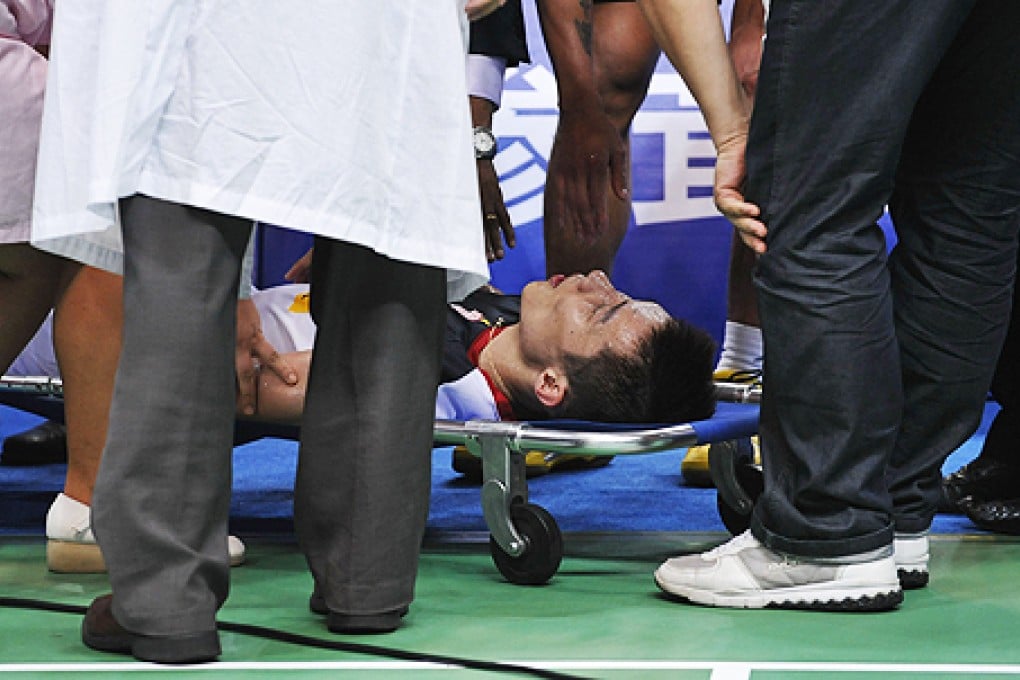 Lee Chong Wei receives medical treatment during the final match against Lin Dan. His coach said he was dehydrated. Photo: Xinhua