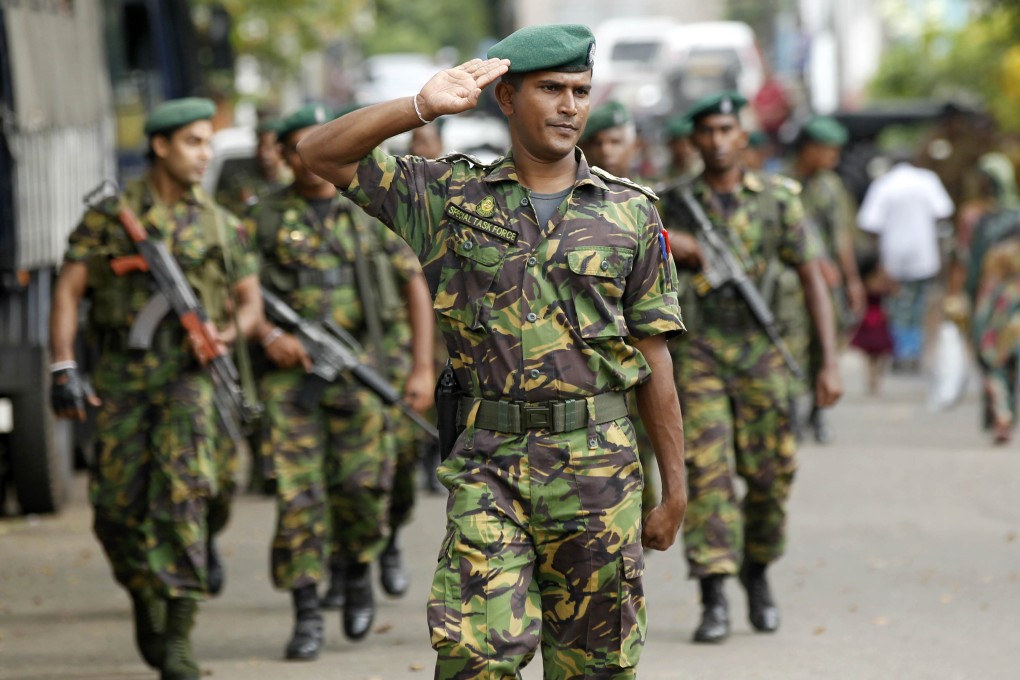 A Sri Lankan police commando salutes as he arrives at the site of a vandalised mosque in Colombo. Photo: AP