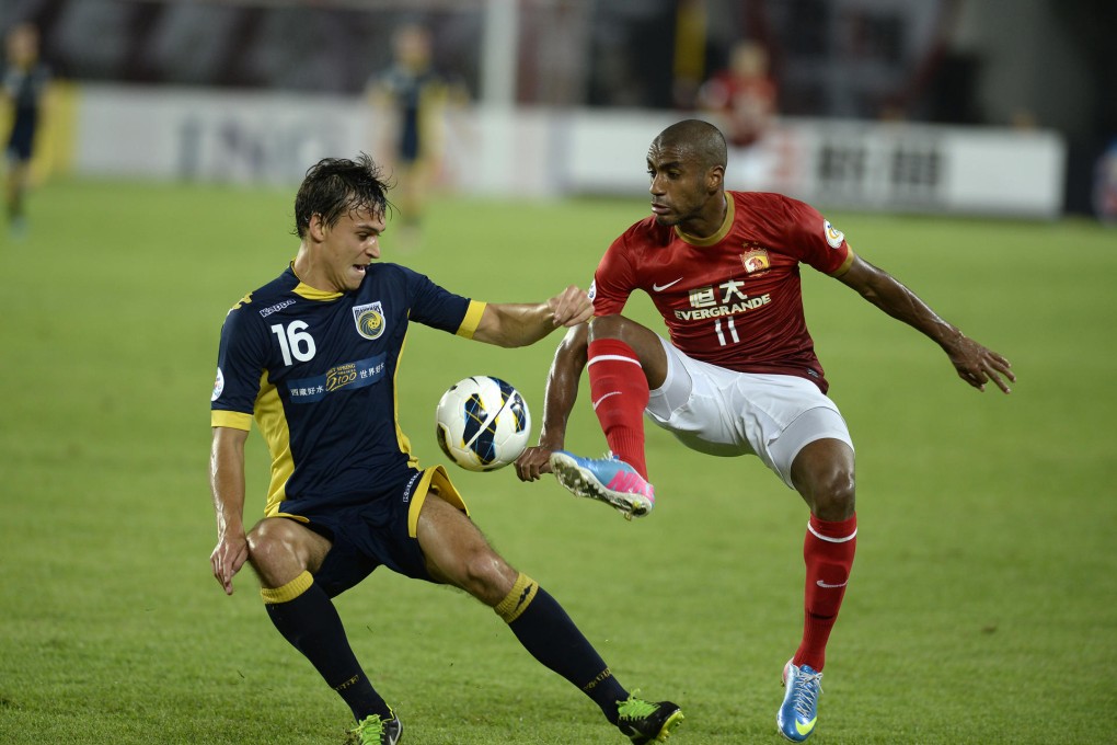 Australia Central Coast Mariners' Trent Sainsbury with Guangzhou Evergrande's Muriqui in the AFC Champions League. Photo: AFP