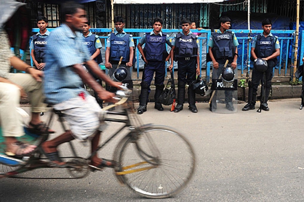 Bangladeshi police stand guard as a rickshaw passes during a nationwide strike called by the Islamist political party, Bangladesh Jumaat-e-Islami in Dhaka on Tuesday. Photo: AFP