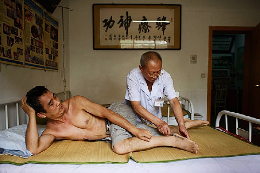 A patient receives a bee sting administered by a doctor of traditional Chinese medicine. Photo: AFP