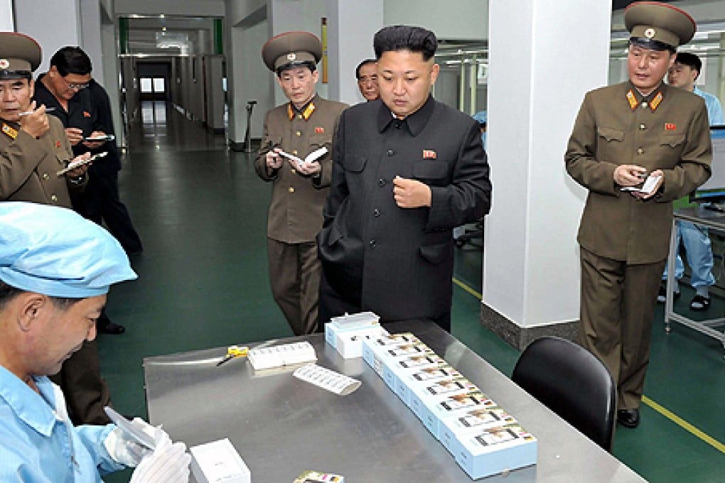 North Korean leader Kim Jong-un inspects the production of touch-screen mobile phone Arirang. Photo: AFP