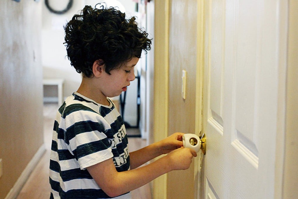 An autistic child tries to open a safety lock at his family home in California. Photo: AP