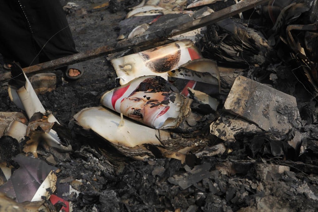 Burned posters of Egypt's ousted president, Mohammed Mursi, remain after protesters were expelled from their camp in Cairo's Nahda Square in a bloody crackdown by troops. Photo: AP