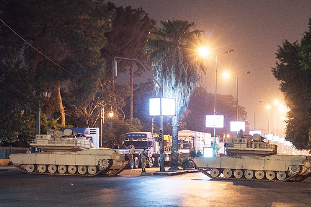 Two Egyptian army tanks block a street on the first day of curfew in Cairo. Photo: Xinhua