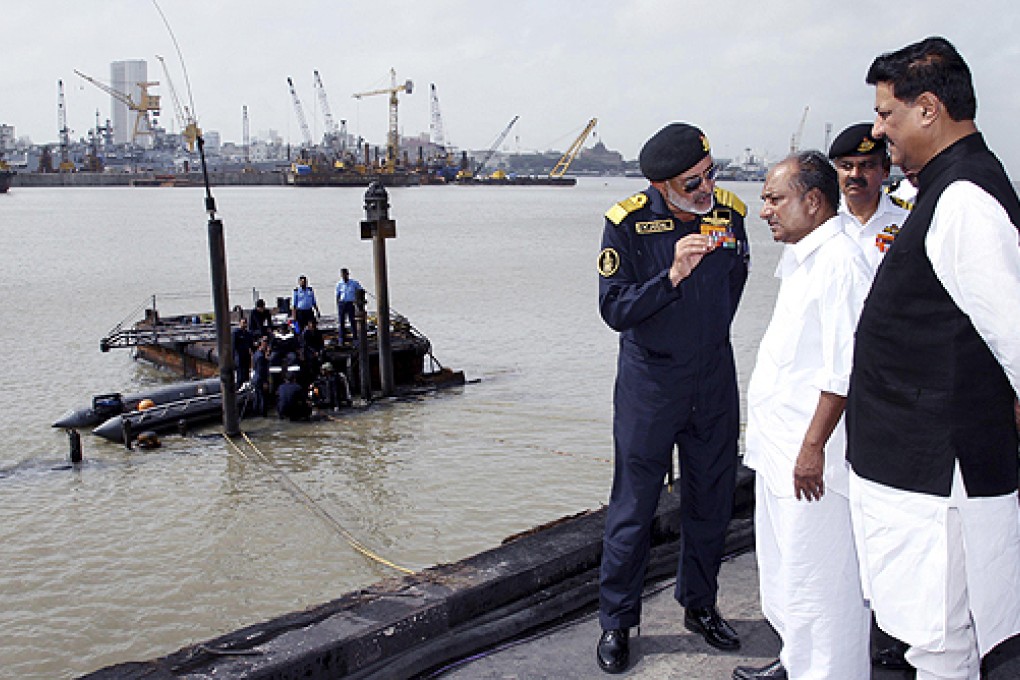 Indian Navy chief Admiral DK Joshi (left) talks with India's Defence Minister AK Antony as navy divers prepare to dive into the waters during a rescue operation in Mumbai. Photo: Reuters