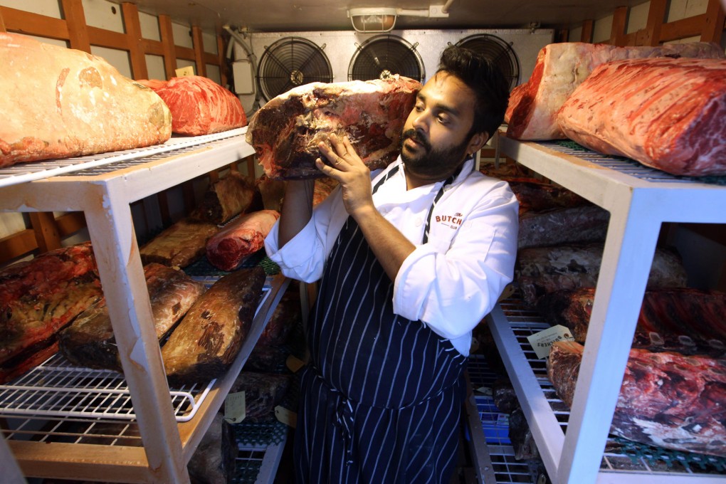 Chef Aarik Persaud gets to grips with a piece of beef in the dry-ageing room at The Butchers Club. Photos: Edward Wong