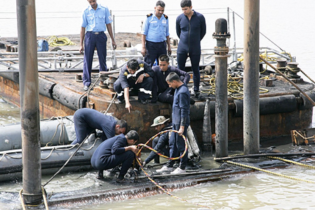 Indian Navy divers and personnel work on the conning tower of the stricken INS Sindhurakshak, after the submarine sank following an explosion at the naval dockyard in Mumbai on Wednesday. Photo: AFP