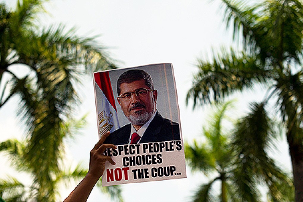 A Malaysian Islamist holds a poster of ousted Egyptian President Mohammed Mursi during a rally after Friday prayers to oppose the military overthrow of the Islamist leader and subsequent killings in Egypt. Photo: AFP