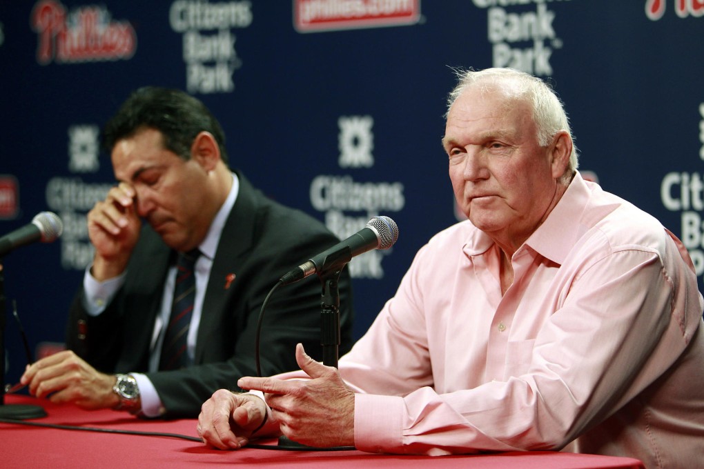 General manager Ruben Amaro Jnr wipes a tear from his eye as Charlie Manuel talks about being sacked as manager. Photo: AP