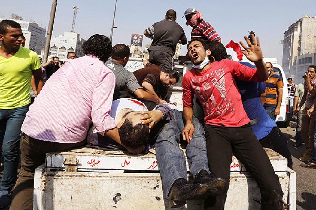 Pro-Mursi protesters transport injured people during clashes at Ramses Square in Cairo. Photo: Reuters