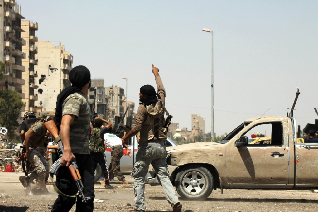 A Syrian rebel points to the sky as a regime fighter jet flies overhead in Syria's eastern town of Deir Ezzor on Saturday. Photo: AFP