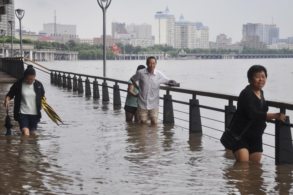 People wade through a street flooded by the overflowing Songhua River in Harbin, Heilongjiang province, on Friday. Photo: Reuters