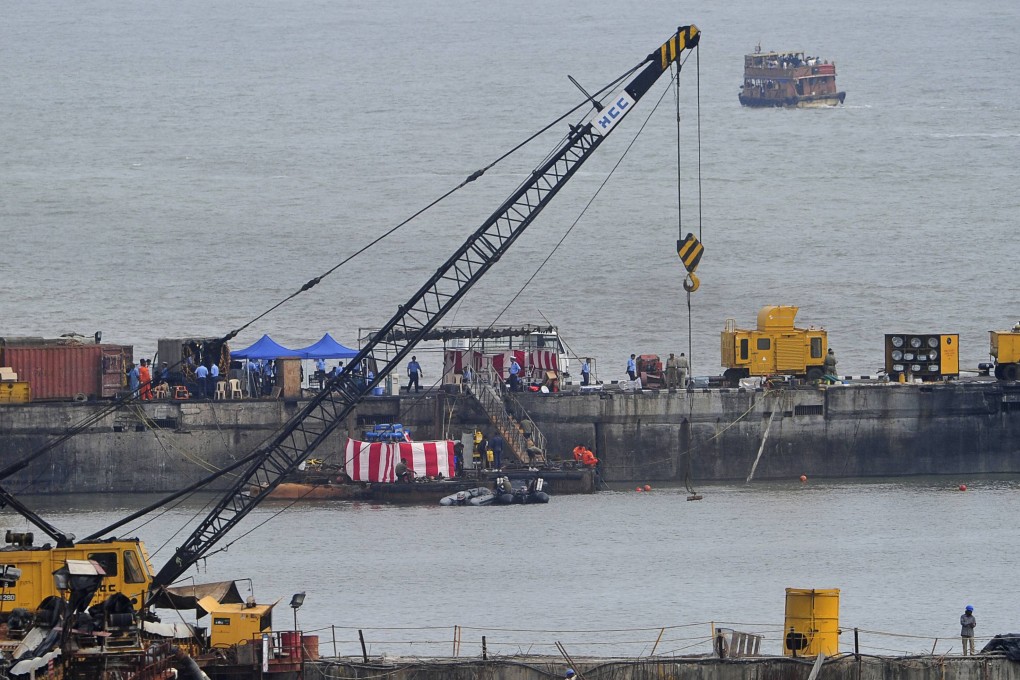 Navy divers and rescue workers stand on the INS Sindhurakshak submarine during a rescue operation. Photo: Reuters