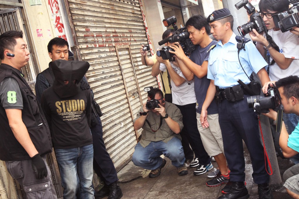 Four of the suspects are taken, hooded and handcuffed, to a flat in Sham Shui Po as part of the investigation. Photo: David Wong