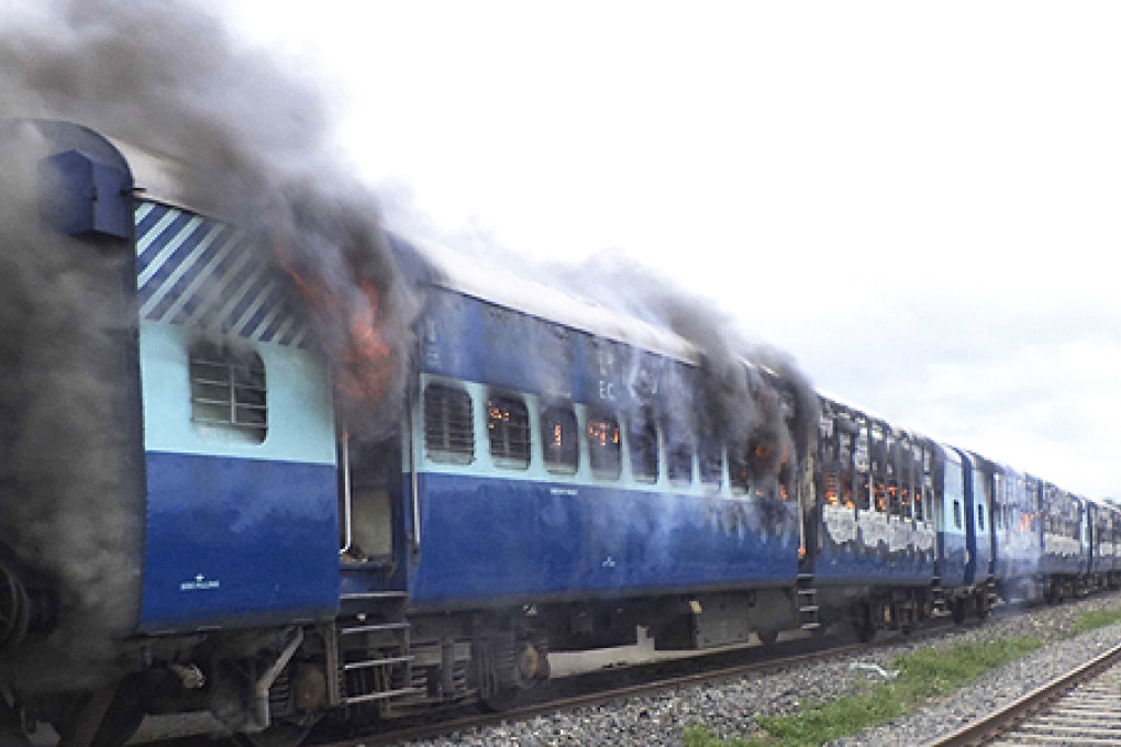 Coaches of the Rajya Rani Express train burn after a mob set it on fire as it ran over a group of Hindu pilgrims at a crowded station in Dhamara Ghat, Bihar state, India, on Monday. Photo: AP